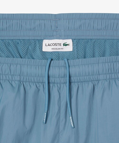 LACOSTE トラックパンツ 水色 LACOSTE（ラコステ） パンツ ワッシャー加工 ナイロン 軽量撥水